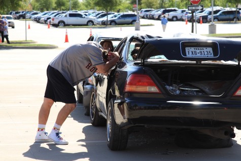 Senior Clayton Bilke leans against a wrecked car in distress during the Shattered Dreams program. In the reenactment, Bilke's decision to drive while intoxicated resulted in the deaths of two students and the paralysis of a third.