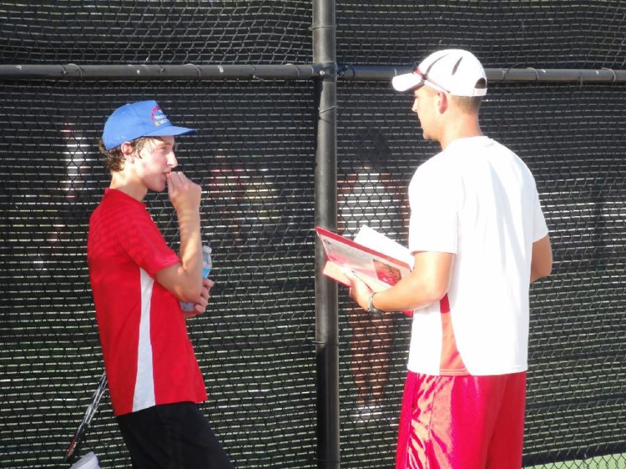 Head coach Adam Cherry and sophomore Jake Hagedorn discuss tennis tactics during a break in action.  