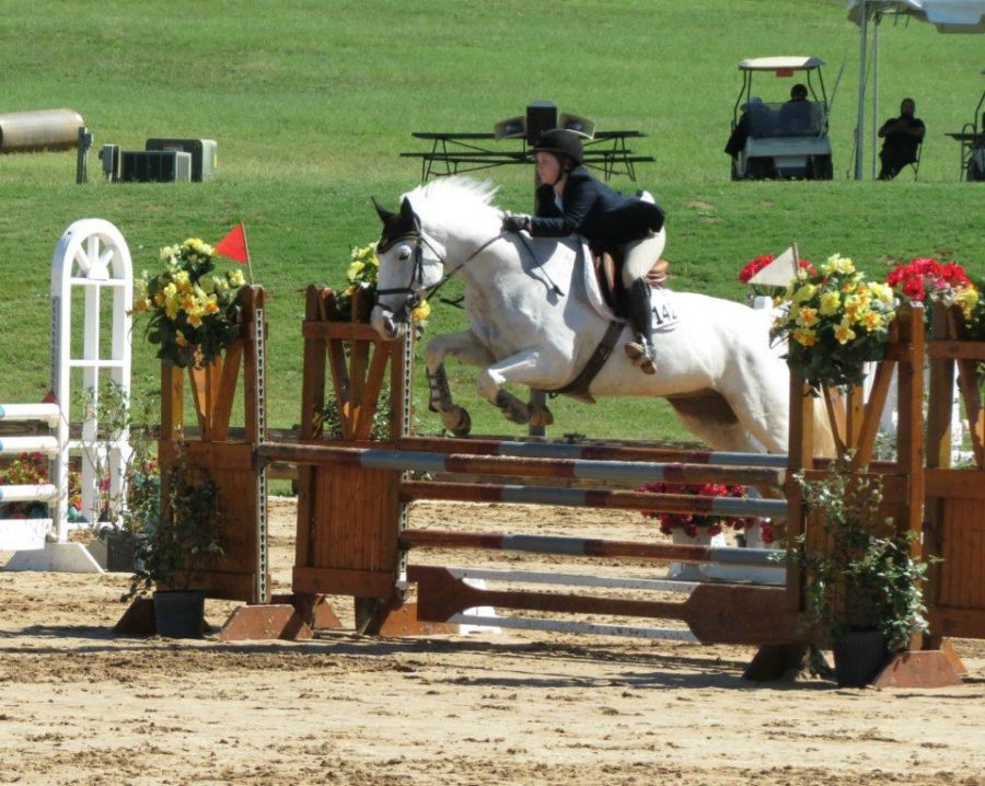 Freshman Kendall Whitt jumping her horse in a show