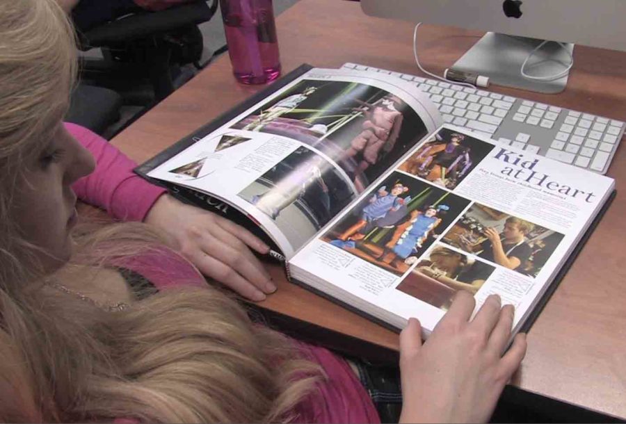 Flipping through the 2011-12 yearbook, senior Amy Minix looks at pictures while waiting for this years book to come out.