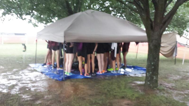 Taking shelter from the storm, members of the cross country team do their best to stay dry in Fayetteville, AR.