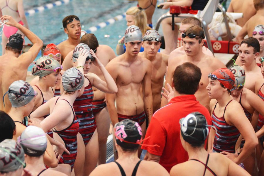 Gathering around coach Greg Fisher, the Leopard swim and diving team listen to instructions at the edge of the pool.  The girls finished in first place while the boys finished in third at the Carrollton Farmers Branch Winter Classic.
