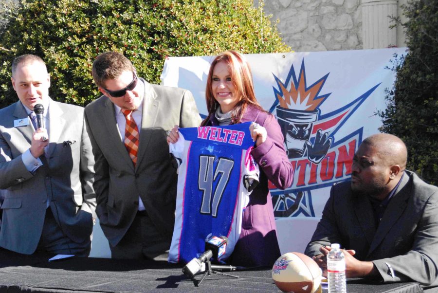 Becoming the first non-kicker to sign a professional football contract, running back Dr. Jen Welter, displays her new Texas Revolution jersey at her contract signing ceremony.