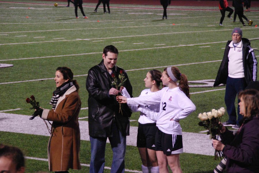 Teacher Jasen Eairheart accepts his an award from the students that chose him to represent their experience at Lovejoy.