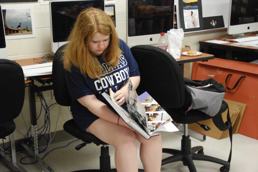 Design editor senior Sarah Hamilton over looks through the Yearbook.