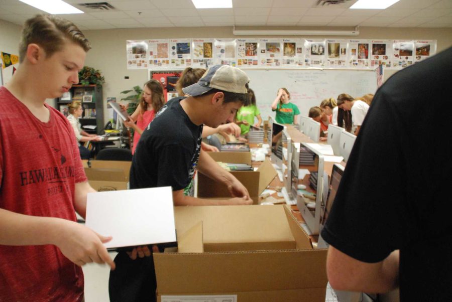 Senior Brad Jacobs open a box to help organize the Yearbooks for the distribution.