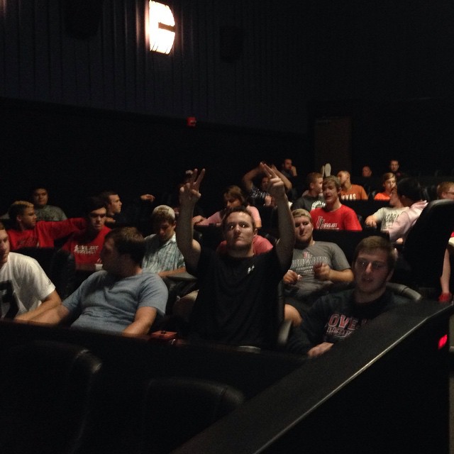 The football team went to see a movie together as a bonding activity on their by week. 