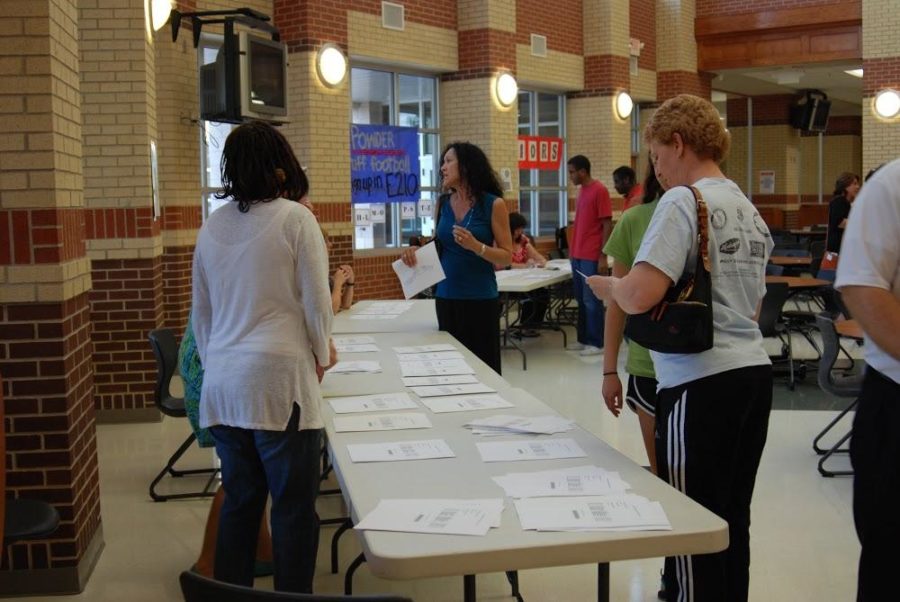 Parents pick up their students schedule as well as a school map at booths labeled by grade.
