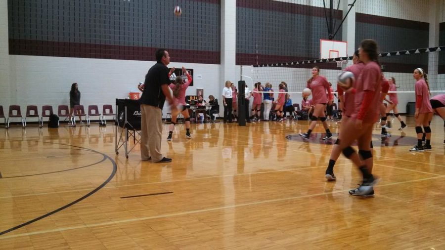 Head volleyball coach, Jason Nicholson, warms up the volleyball players at J.J. Pierce High School.