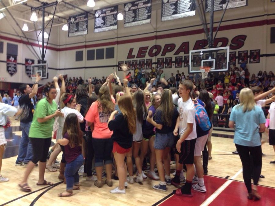 Seniors rush to the gym floor in a huddle after their win.