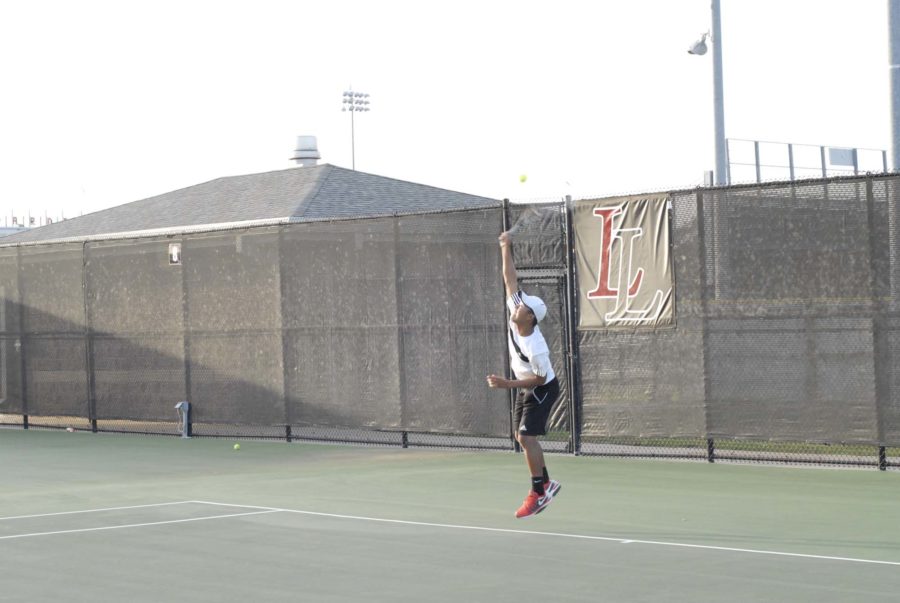 A Lovejoy tennis player saves the ball from going out of the court.