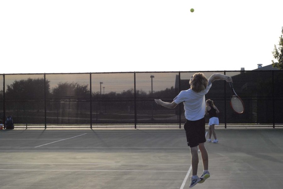 A Lovejoy tennis player tosses up the ball before striking it towards the McKinney side on October 7, 2014.