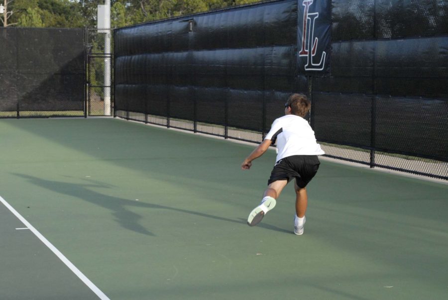 Junior tennis player Grady Wells goes after the ball to continue the volley. 