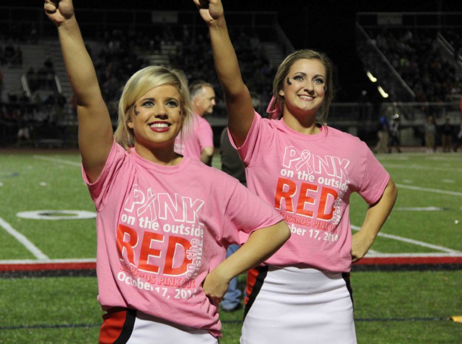 Senior+Emily+Norwood+and+senior+Taylor+Kort+cheer+during+the+Pink+Out+Game+in+honor+of+breast+cancer.+