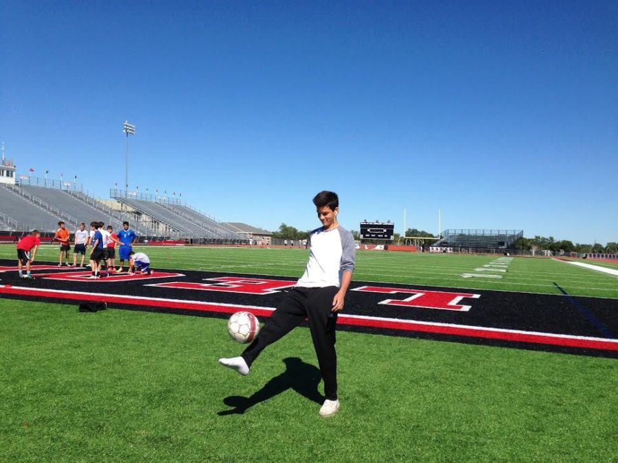 After school, Freshman Grant Lange, dribbles around a soccer ball. 