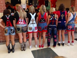 Adorned with glitter, bows and other leopard themed trinkets, senior girls pose on the Friday before a home game.