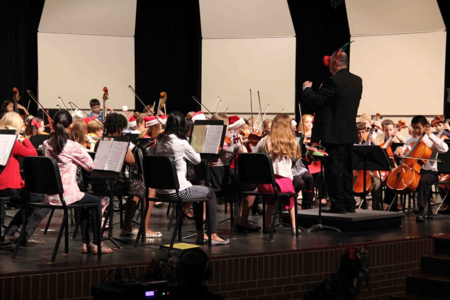 Joey Sloan, Orchestra instructor, puts on antlers and a huge pair of glasses in hopes to not only make the crowd laugh, but to calm the nerves of his orchestra students as they perform.