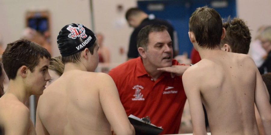 Head Swim Coach Greg Fisher speaks with some of his swimmers about technique prior to a race.