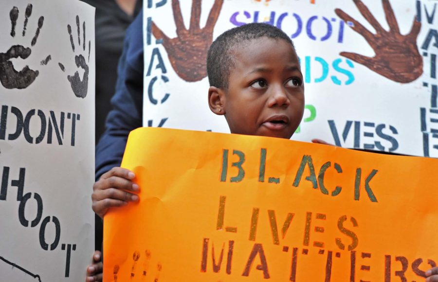 Marquise Miller, 8, who came with his mother, holds a sign outside Marietta Municipal Court during their peaceful demonstration against decisions not to indict white police officers in the deaths of unarmed black men in Ferguson, Mo., and in New York City on Saturday, Dec. 6, 2014 in Marietta, Ga. 
