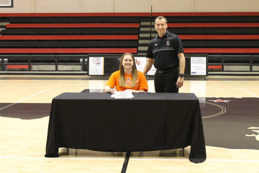 Lance Boxell, head basketball coach, stands alongside Samantha Odom after signing her letter of intent to play womens basketball for the University of Texas as Tyler.