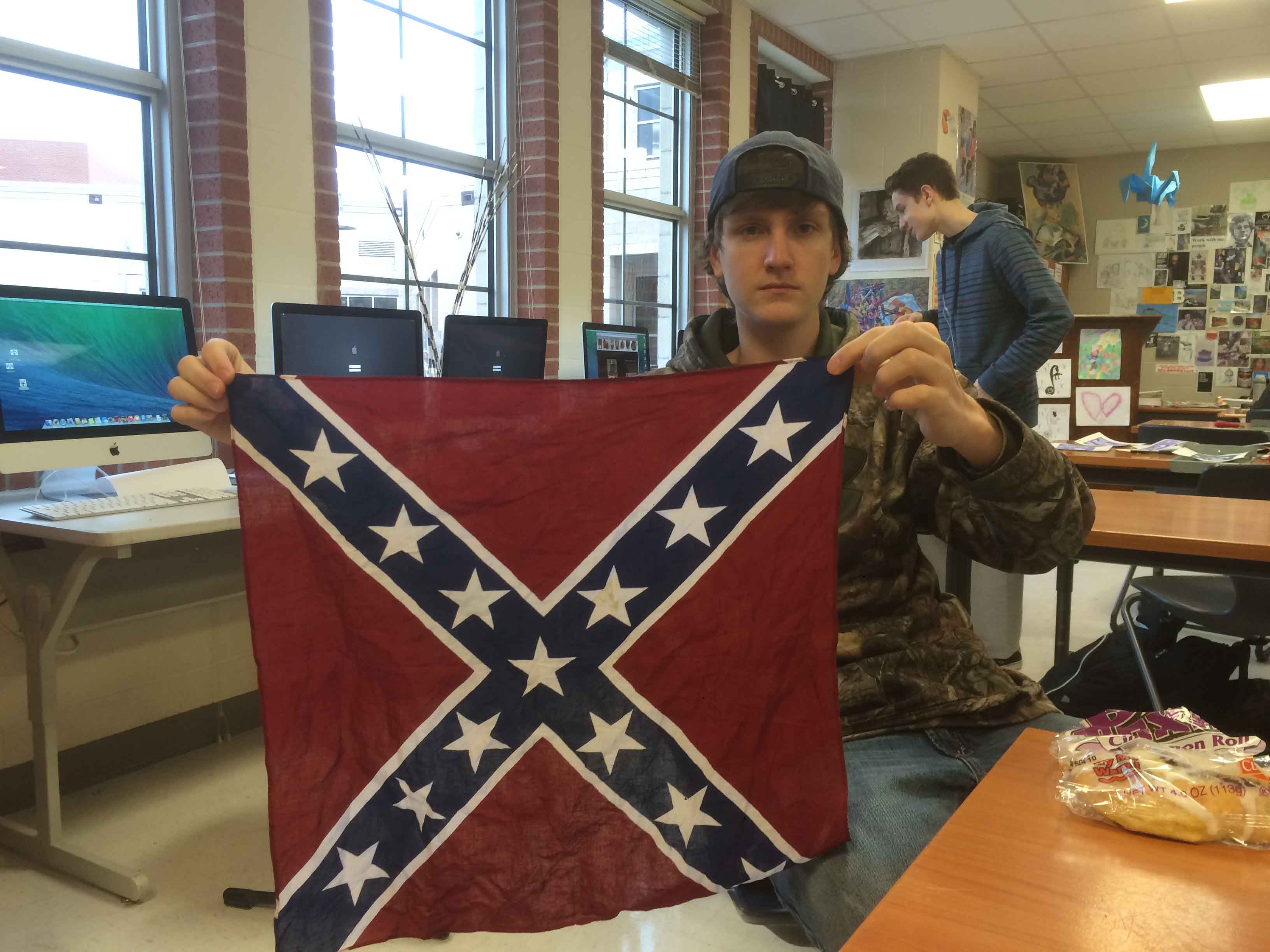 Sophomore Davis DeShields displays a small Confederate flag, however school administration has determined the flag is no longer allowed on campus.
