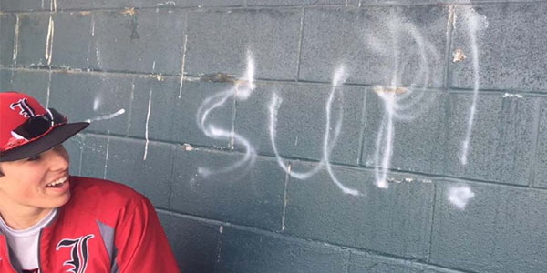 Graffitti on the wall of the baseball dugout was quickly removed once it was noticed by the team. Here, senior Brandon Provence looks at what the team jokingly calls the "wall of encouragement". 