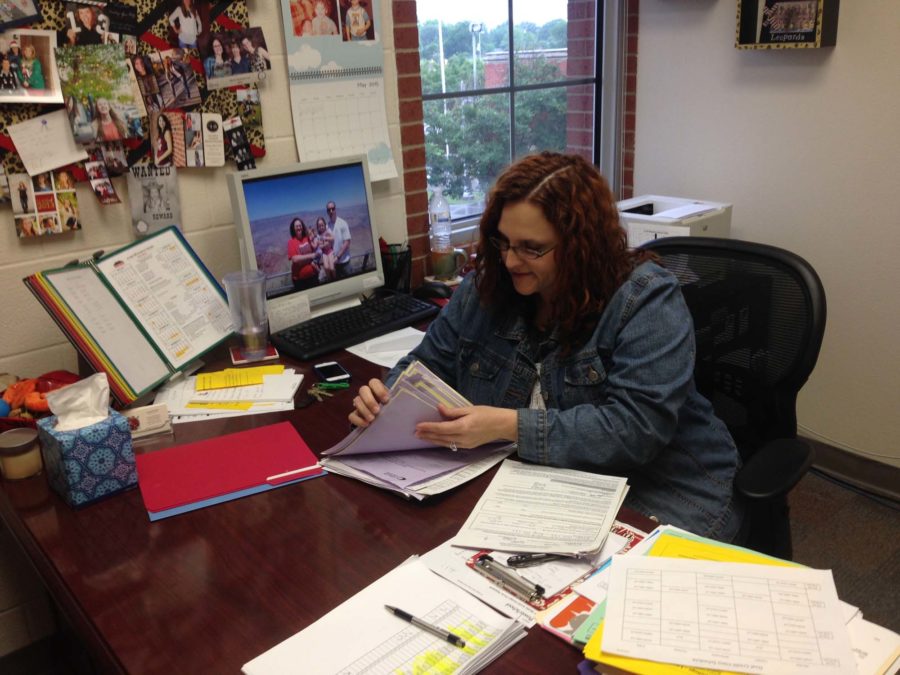 Sorting through papers at her desk, counselor Amanda Breeden and others must look at thousands of variables when putting together student schedules.