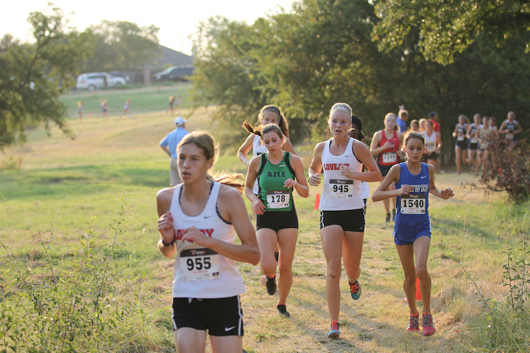 Just after an 8:30 a.m. start, senior Ariaan Cnossen looks to sophomore Emily Gueller while continuing in her 5k.