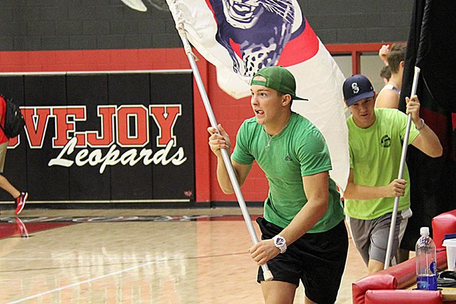 Junior cheerleader Abe Dueck and others commanded the LHS flags during the sophomore vs. junior game, running the flags around the gym after each touchdown.