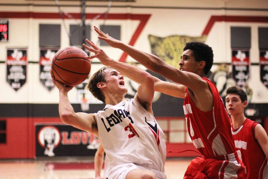 Senior Braden Ledebur goes for a layup against the Woodrow Wilson defender.