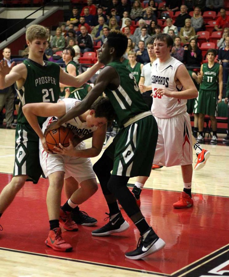 Surrounded by opposing team, Prosper, Freshman Micheal Difiore tears ball away from opponent.