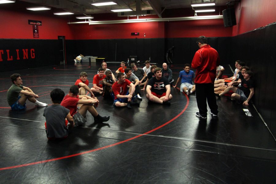 Coach Mike Eaton addresses the boys wrestling team during a practice. The boys and girls are in action tonight in McKinney.