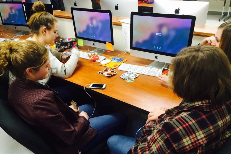 Students in Jennifer Holcomb's fifth period photojournalism class play Uno during the Internet outage on Thursday. The students served as models for other photographers taking action photos while Photoshop was unavailable. 