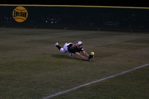 Sophomore Kim Lyne, playing right field, attempts to catch a fly ball in the outfield.