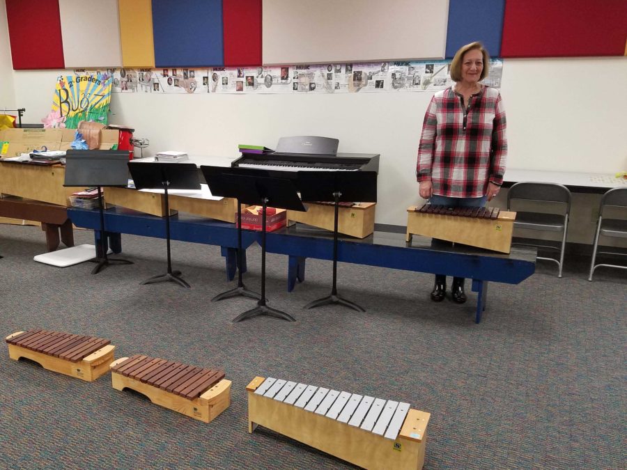 Retiring staff member Debbie Noble stands among some of the instruments she uses to instruct her students at Hart Elementary