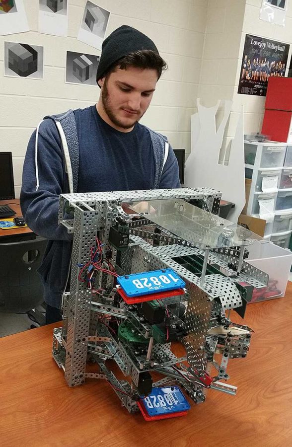 Junior Josh Blumenthal works on the drivetrain for robot 1082B in the robotics room. Blumenthal is the mechanical designer for the robot which launches nerf ball projectiles into colored nets. Blumenthal will be part of the group taking the robot to competition in Kentucky this week for the Vex Robotics World Competition.