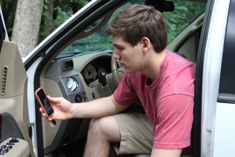 Jack Supan sits in truck loading a tracking app used by his parents to monitor his driving.