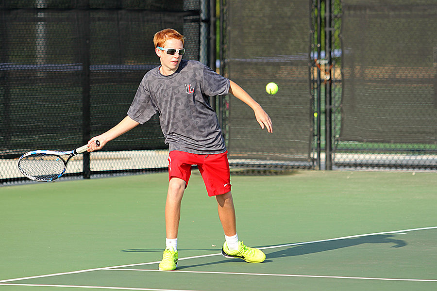 Sophomore Caiden Tays returns a shot for the boys tennis team.