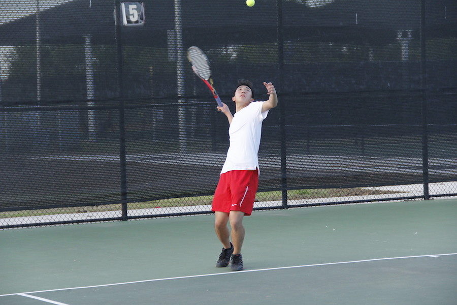 Junior Brandon Su serves to his opponent.