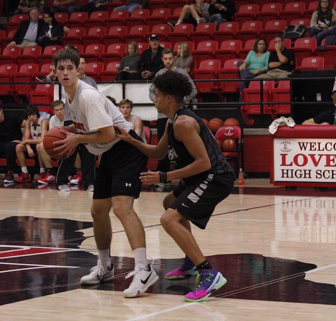 Senior Jackson Carswell holds onto the ball and looks for an open man just past half court.