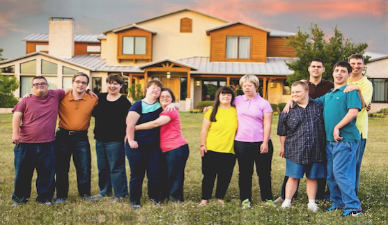 Residents of the Cornerstone Ranch housing program pose outside of one of the structures. Through the program, the adults sell jewelry, make candles, serve others, and grow vegetables among other activities.