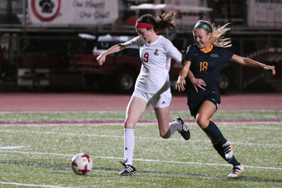 Sophomore Kassidy Litchenburg runs down the pitch with the ball.