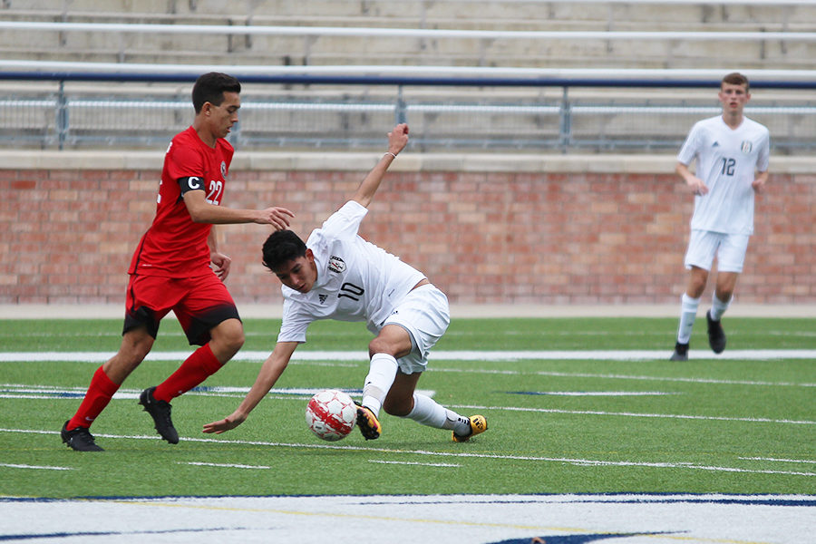 Junior Enrique Vega tries to slip past a Colleyville Heritage defender at Eagle Stadium on Thursday. The Leopards tied Heritage 1-1 in the season opener.