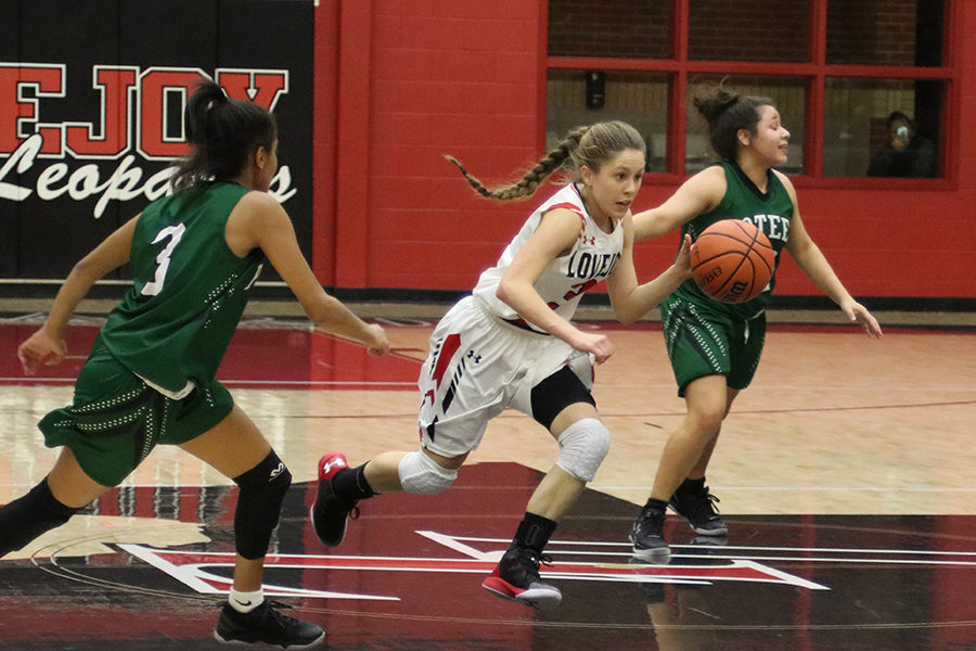 Junior Meredith Ehlman dribbles past Poteet defenders on Jan. 10.