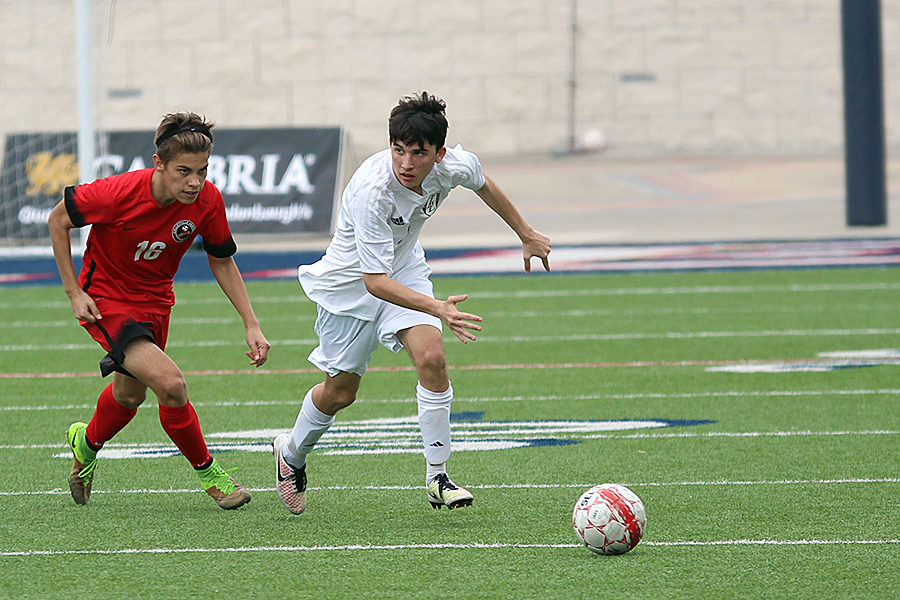 Junior Kishan Vasal races to beat a Colleyville Heritage defender to the ball last Thursday at Eagle Stadium in Allen.