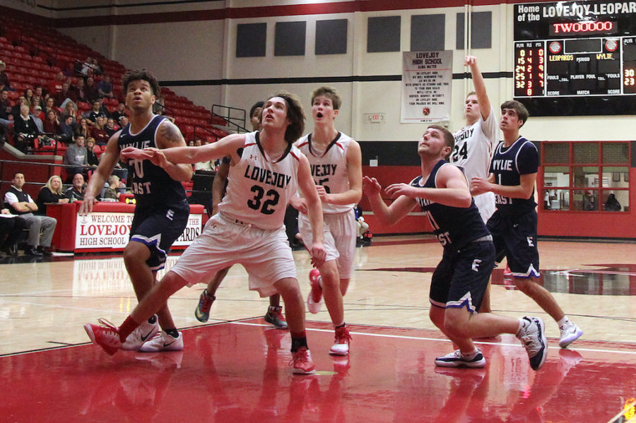 Junior Jack Supan blocking out Wylie East players from grabbing the rebound.