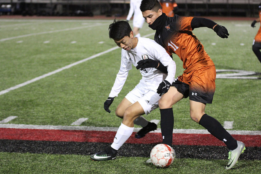 Senior Christian Kwon fights West Mesquite winger for the ball.