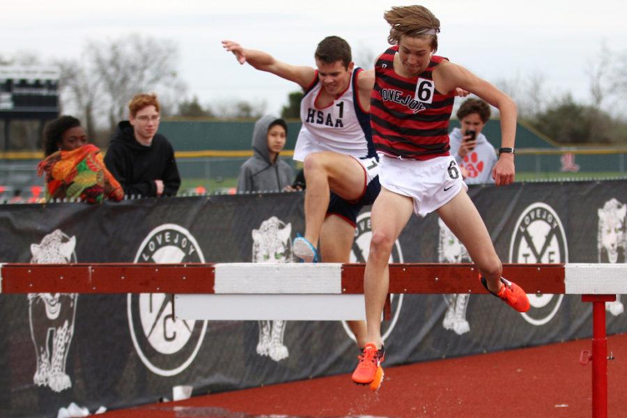Freshman Whitson Bedel jumping over the steeple chase barrier.