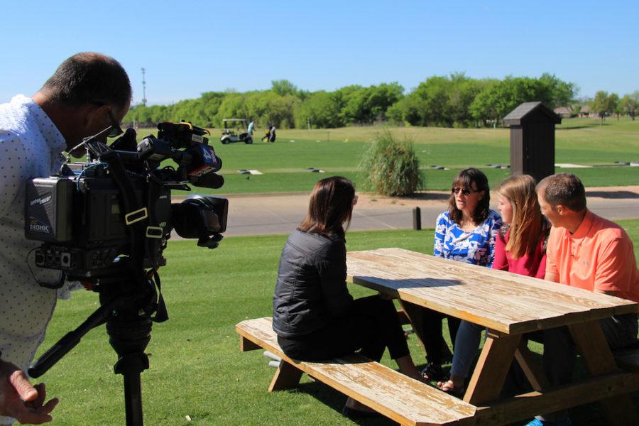 Junior Savanna Roulette sits with her mother Trish and golf coach Kevin Johnson as she is interviewed by FOX 4 regarding her charity golf tournament.