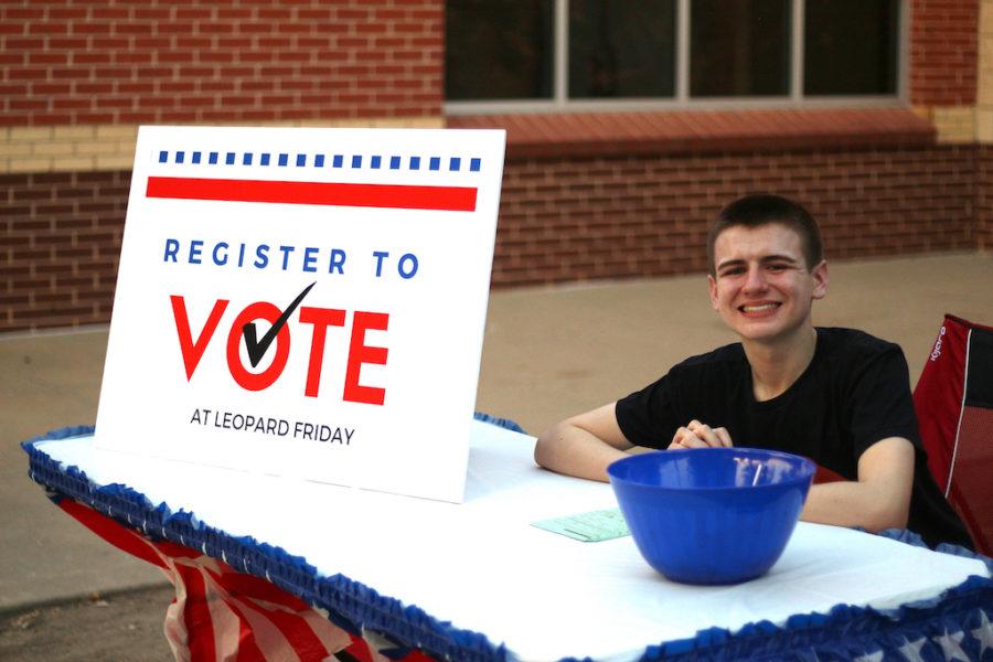 Senior Grant Durow sits at his booth raising awareness for Texas' low voter turnout as part of his senior project.